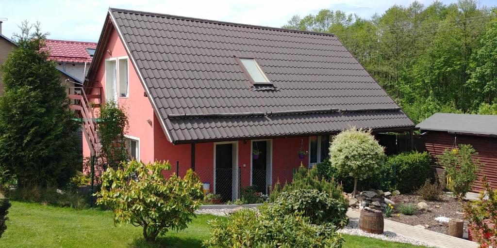una casa rossa con tetto nero di Podkroví - ubytování Brdy a Bohutín