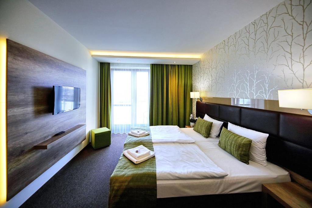 Postel nebo postele na pokoji v ubytování Nádas Tó Park Hotel