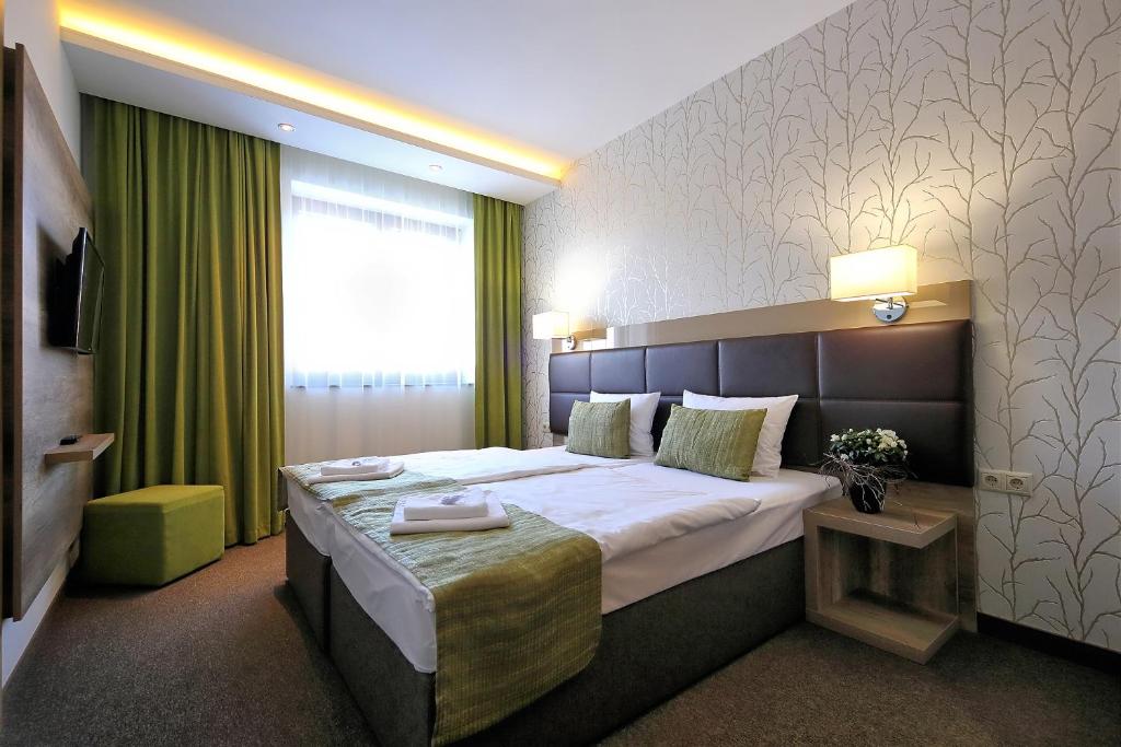 Postel nebo postele na pokoji v ubytování Nádas Tó Park Hotel