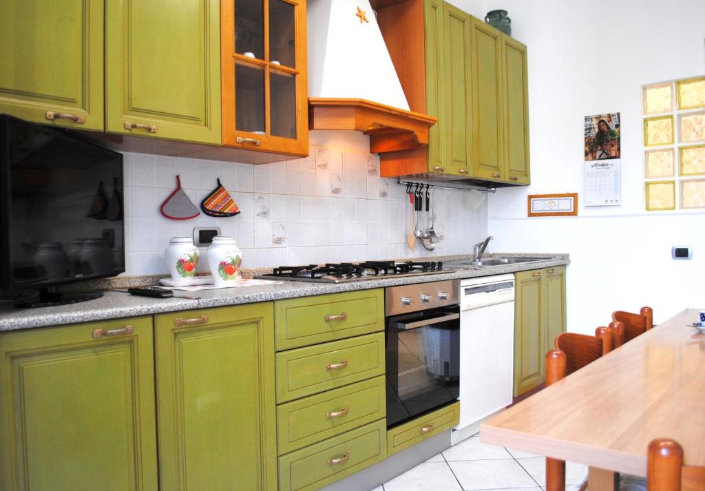 eine Küche mit grünen Schränken und einem Herd Top-Backofen in der Unterkunft BNBOOK - BORROMEO 1 in Rho