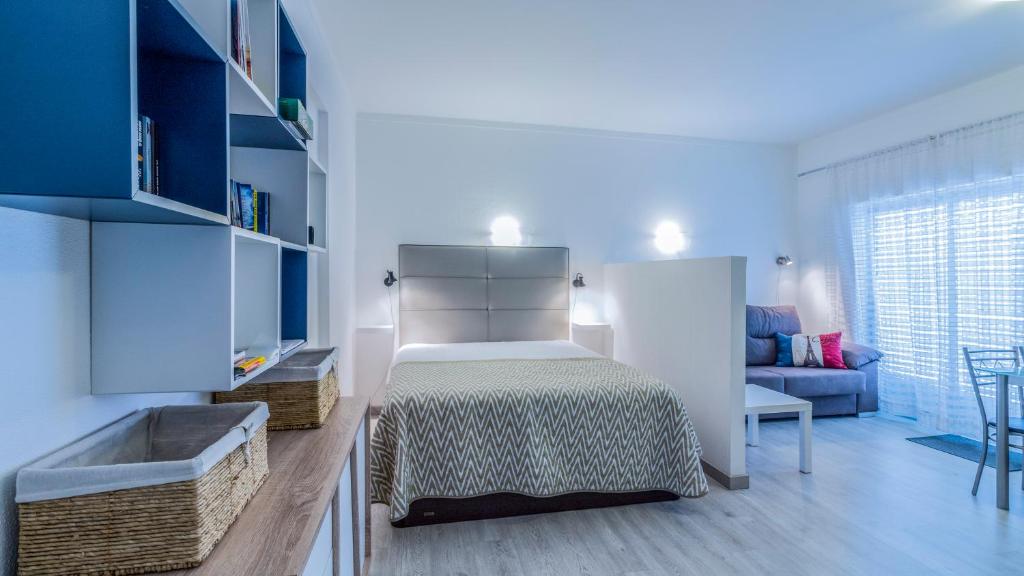 a bedroom with a bed and a couch in a room at Estudio Centro de Alvor in Alvor