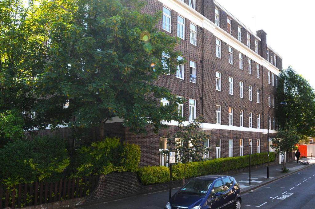 un coche azul estacionado frente a un edificio de ladrillo en Abercorn House, en Londres