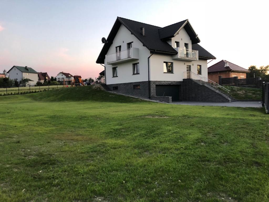 a house on a hill with a green yard at Holiday home Limanowa in Limanowa