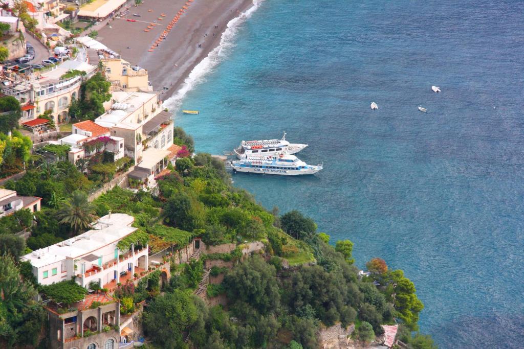 statek wycieczkowy w wodzie obok plaży w obiekcie IL PARADISO DEGLI DEI 2 w mieście Agerola