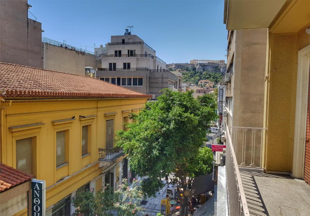 Blick auf eine Stadtstraße von einem gelben Gebäude in der Unterkunft Let me Athens you! in Athen