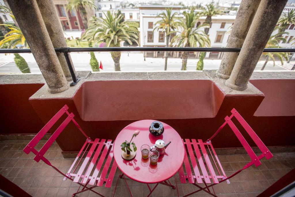 une table rose et deux chaises sur un balcon dans l'établissement Junior Suite Balima I B43, à Rabat