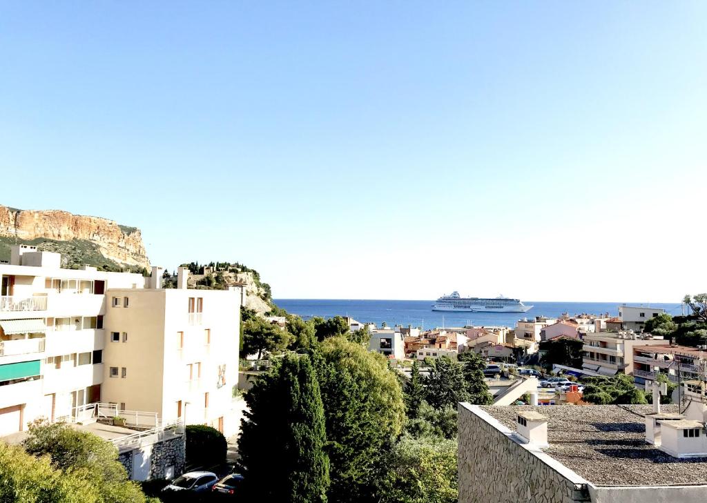 - une vue sur une ville avec un bateau de croisière dans l'océan dans l'établissement La Viguerie, à Cassis