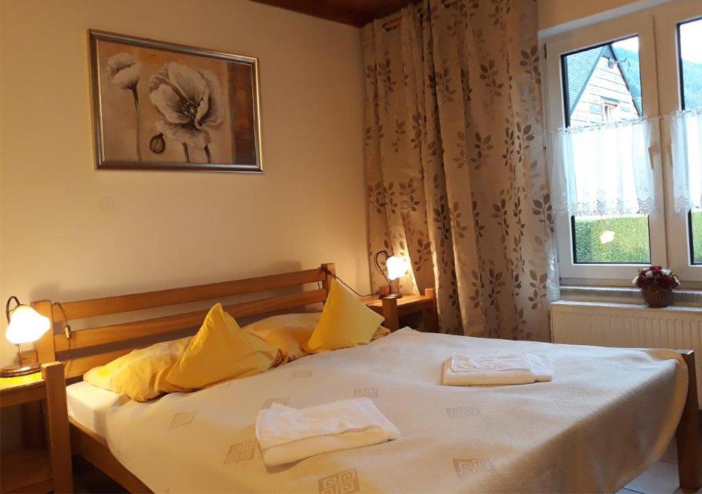 a bedroom with a bed with two towels on it at Mała Maggie in Szczyrk