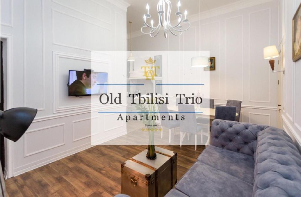 ein Wohnzimmer mit einem Sofa und einem Kronleuchter in der Unterkunft Old Tbilisi Trio Apartments in Tbilisi City