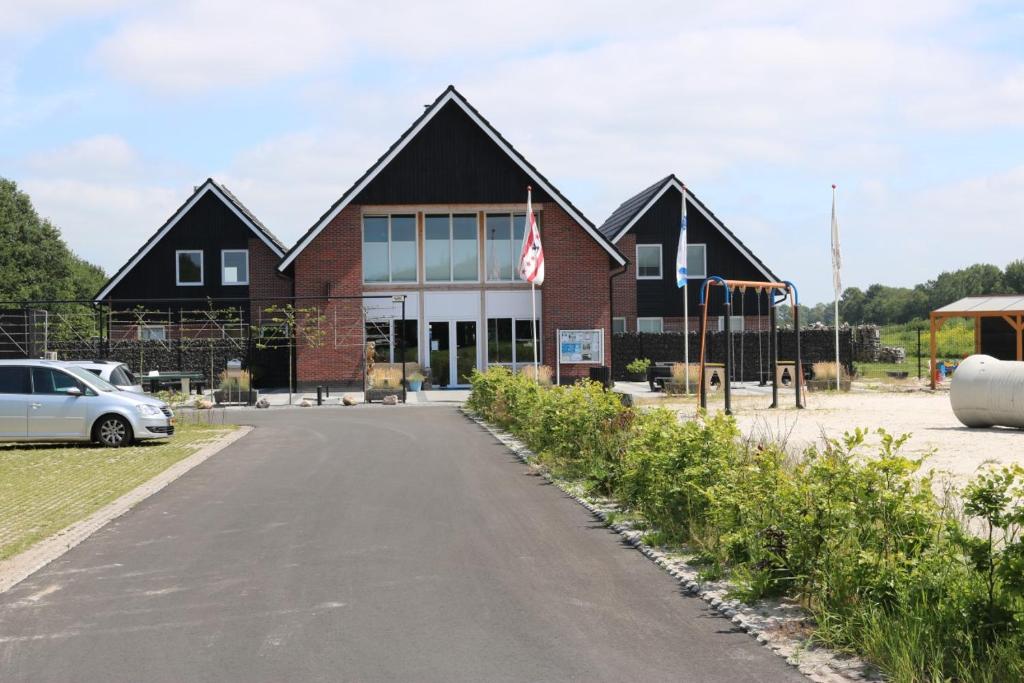 un bâtiment avec une voiture garée devant lui dans l'établissement Vakantiepark De Kremmer, à Gasselte