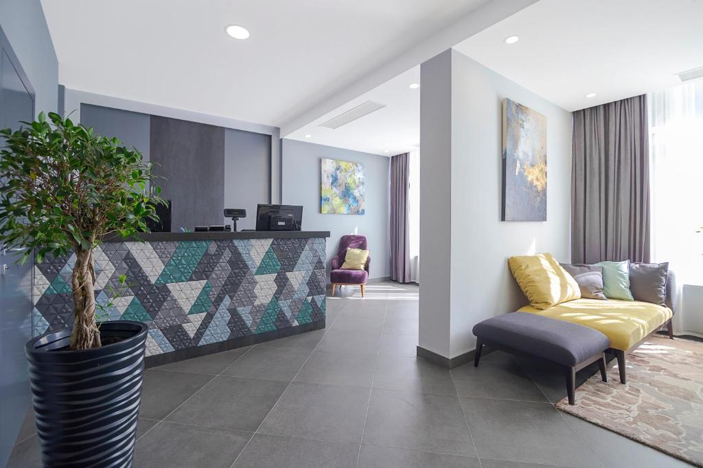a lobby with a couch and a chair and a plant at Favor Sport Hotel in Kyiv