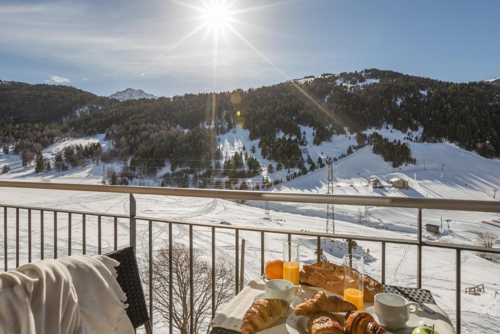 a table with food on a balcony with a ski slope at Pierre & Vacances Andorra Bordes d’Envalira in Bordes d´Envalira 