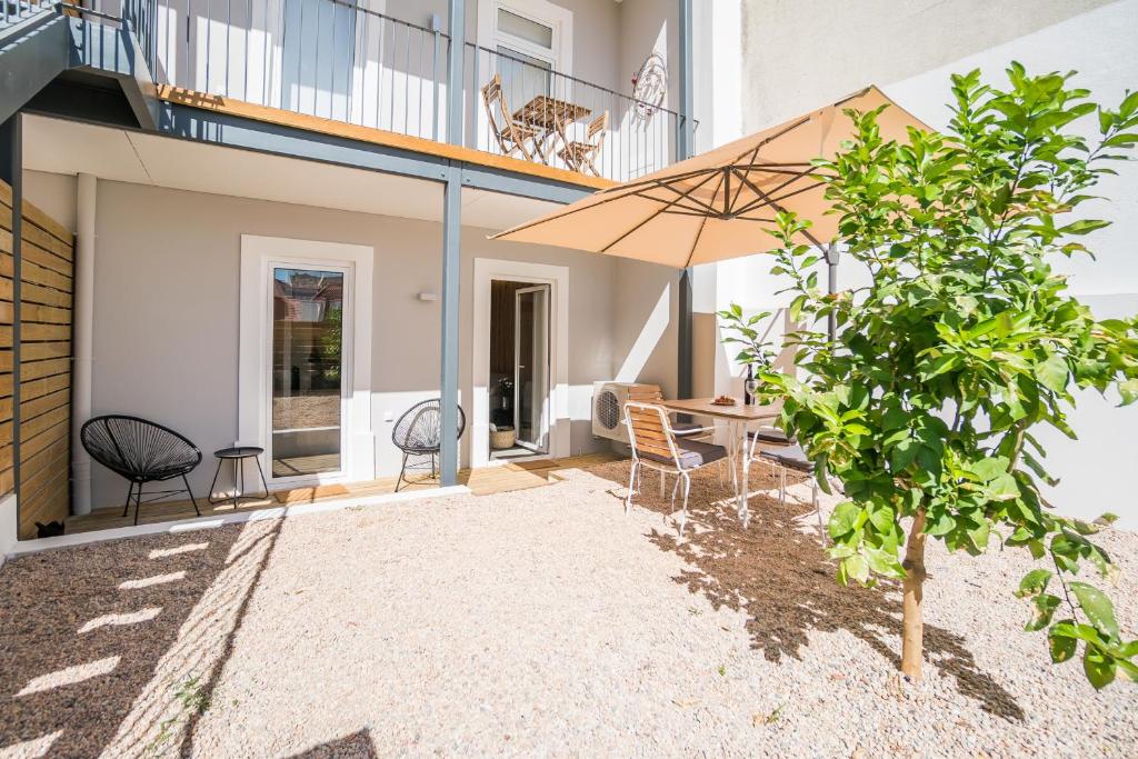 um pátio com uma mesa e um guarda-chuva em Wood Wall & Garden Apartment em Lisboa