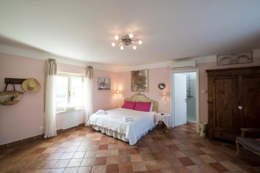 Schlafzimmer mit einem Bett, einem Fenster und einem Kronleuchter in der Unterkunft Residence La Pera Bugiarda in Venaria Reale