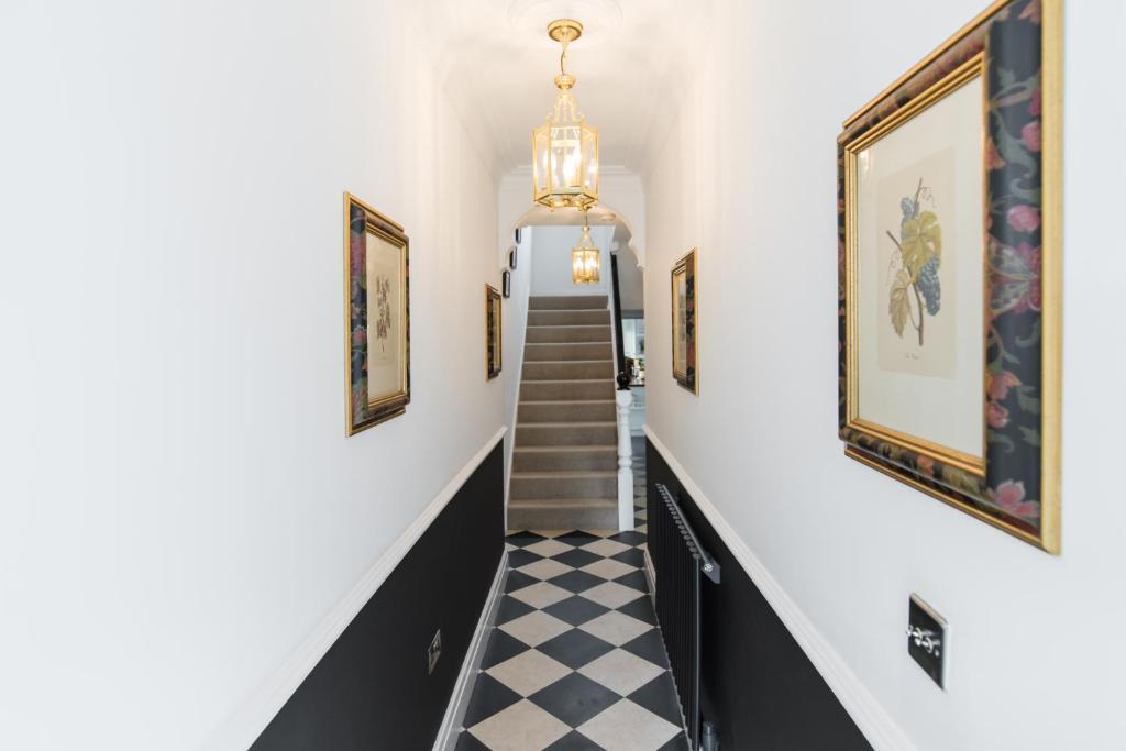 a hallway with stairs and paintings on the walls at 145 New Road in Porthcawl