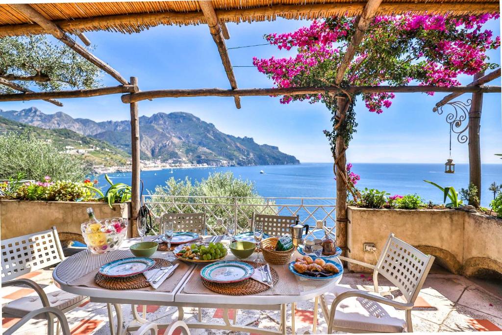 een tafel met eten en uitzicht op de oceaan bij Star Fish House in Amalfi