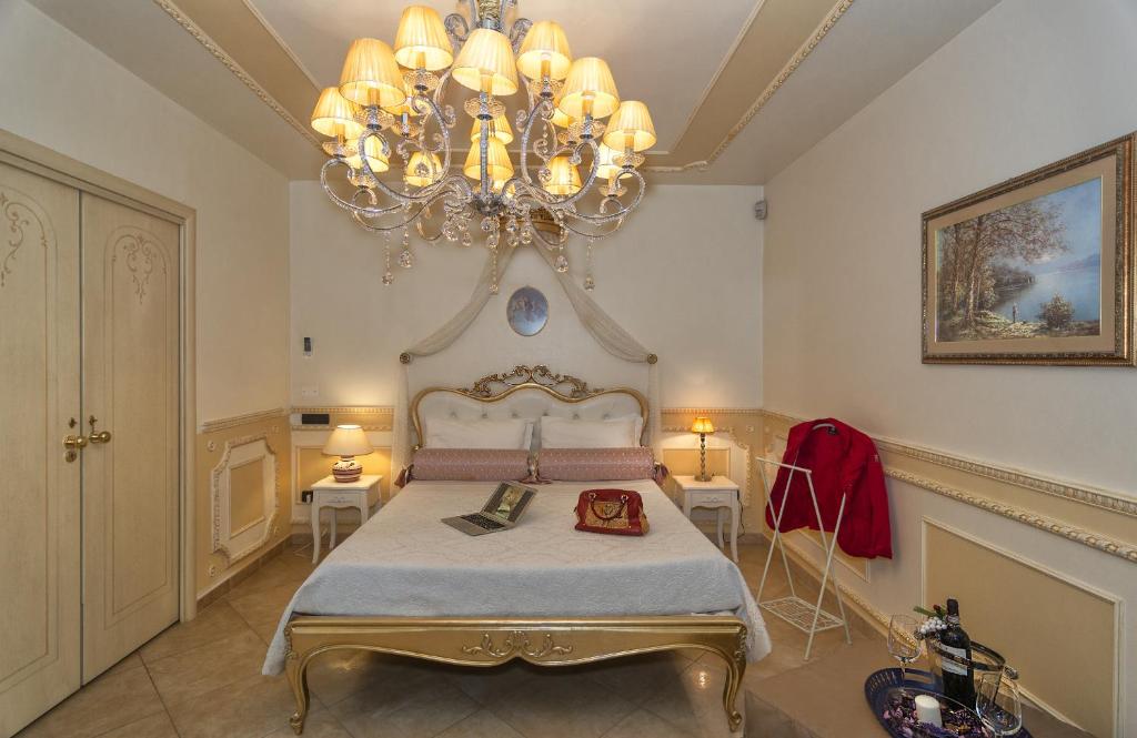 1 dormitorio con 1 cama grande y lámpara de araña en Il Dolce Sospiro, en Pisa