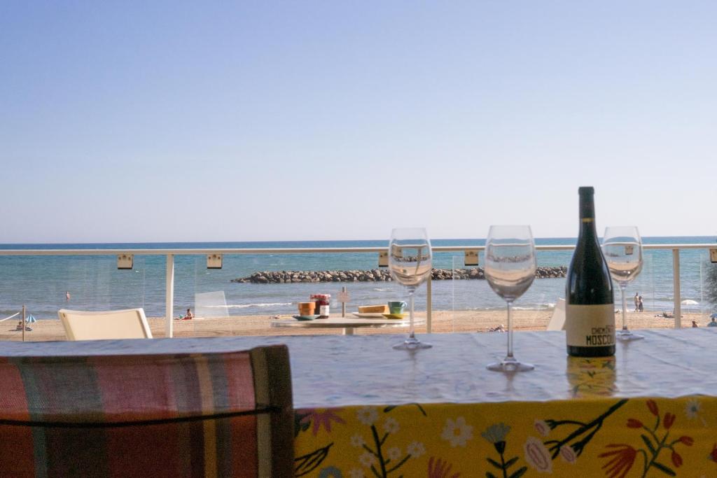 a table with wine glasses and a view of the beach at Bel appart vue mer in Valras-Plage