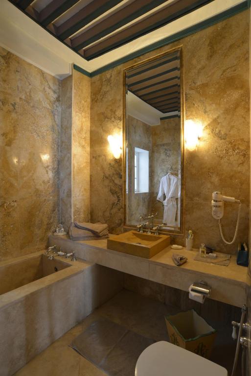 a bathroom with a tub and a sink and a mirror at Palais Bayram in Tunis