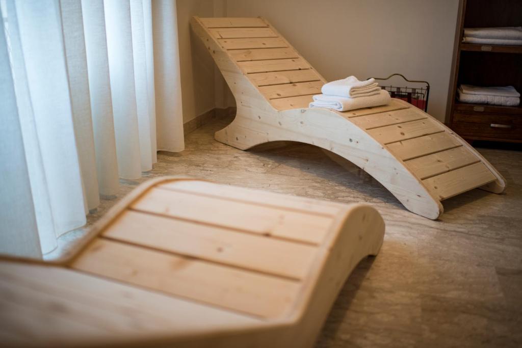 una panca di legno seduta in una stanza accanto a una finestra di B&B La Vetta -petite SPA- a Potenza