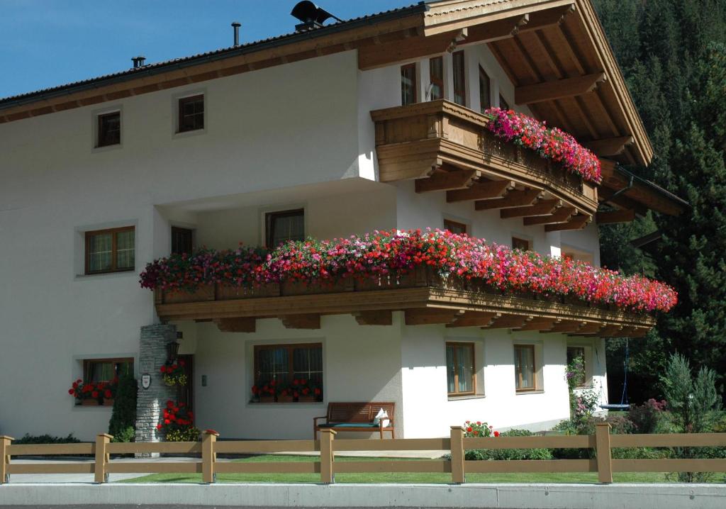 ein Gebäude mit einem Balkon mit Blumen darauf in der Unterkunft Ferienwohnung Johanna in Tux