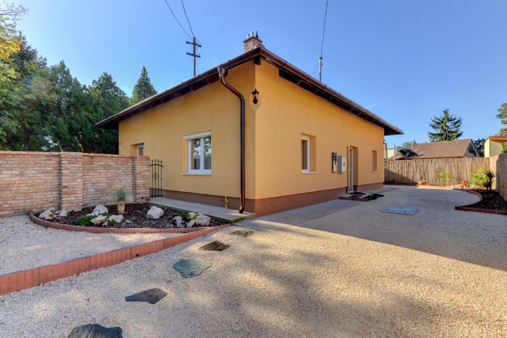una piccola casa gialla con un mattone di Anita a Budapest