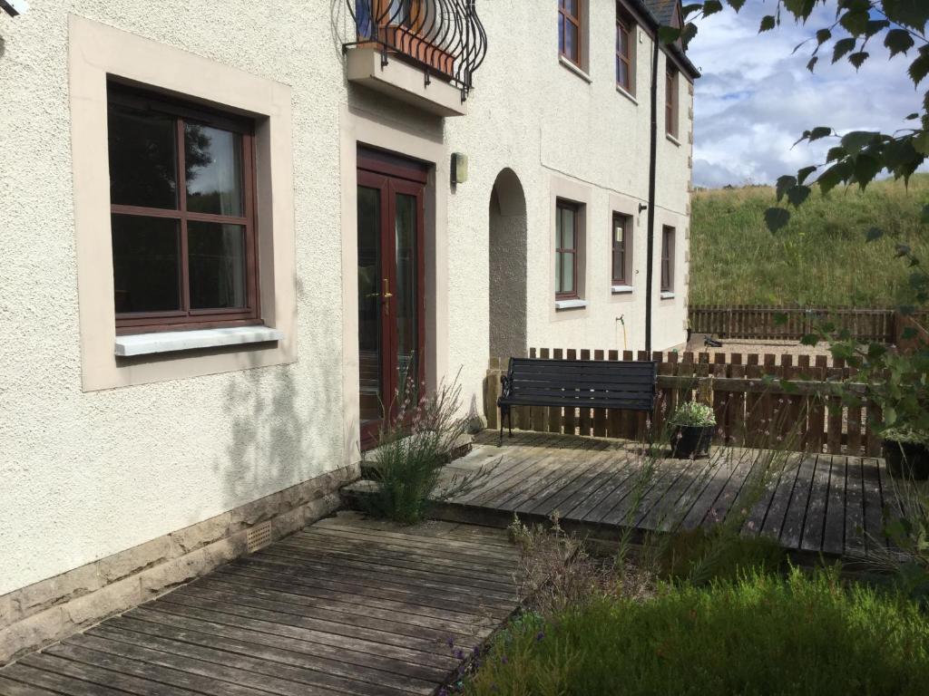 a building with a bench next to a door at Two-Bedroom Apartment - Golf View Free Parking in Inverness