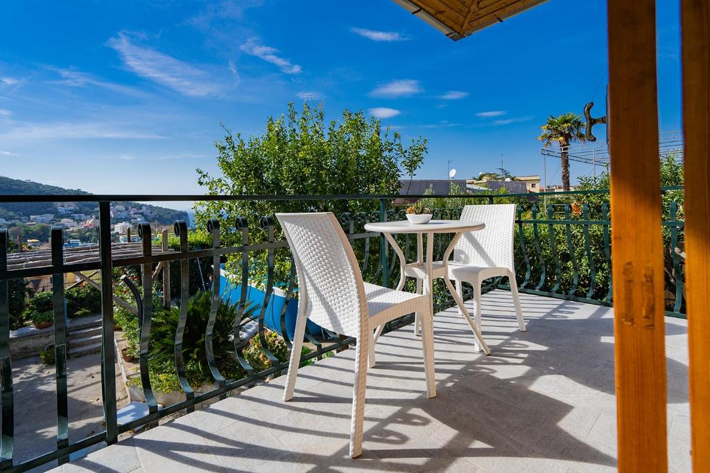 a patio with two chairs and a table on a balcony at Villa Russo in Vico Equense