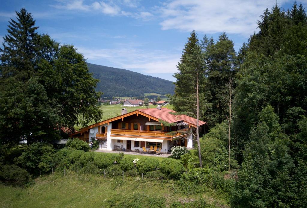 ein Haus inmitten eines Feldes mit Bäumen in der Unterkunft Ferienwohnung am Römerweg Wald in Inzell