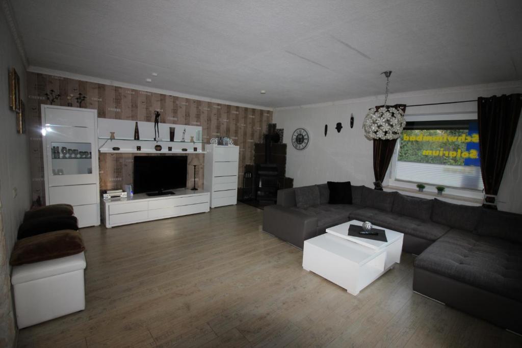 a living room with a couch and a table at Haus Abbi, Ferienwohnung mit Schwimmbad in Hage