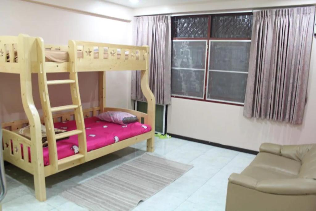 a bedroom with a bunk bed and a couch at D-Toys Homestay in Khon Kaen