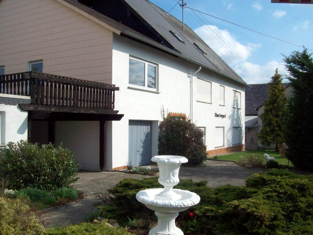 um vaso branco em frente a uma casa em Haus Irmgard em Schlierschied