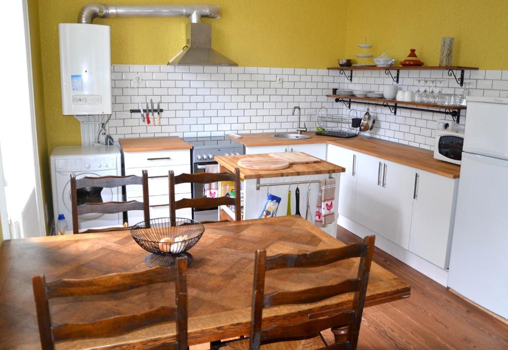 ペリグーにあるJoli appartement vue sur l'Egliseのキッチン(木製のテーブル、椅子付)
