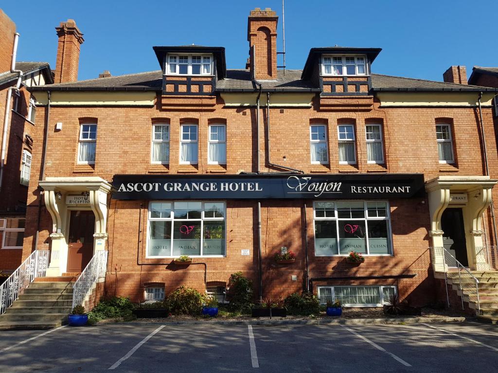 um edifício de tijolos com um sinal para um hospital de telhados em Ascot Grange Hotel - Voujon Resturant em Leeds