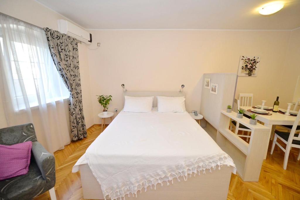 Schlafzimmer mit einem großen weißen Bett und einem Schreibtisch in der Unterkunft Apartment Filip in Kotor