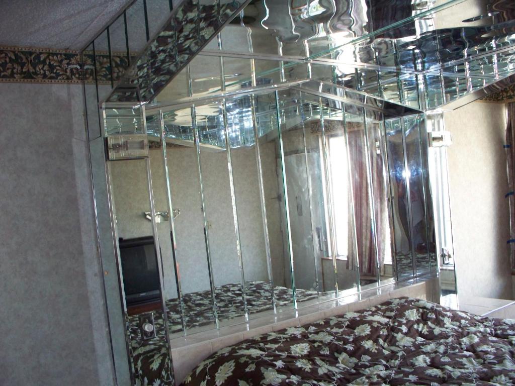 Cette chambre est dotée d'une paroi en verre avec un lit et un miroir. dans l'établissement Executive Inn Coopersburg, à Coopersburg