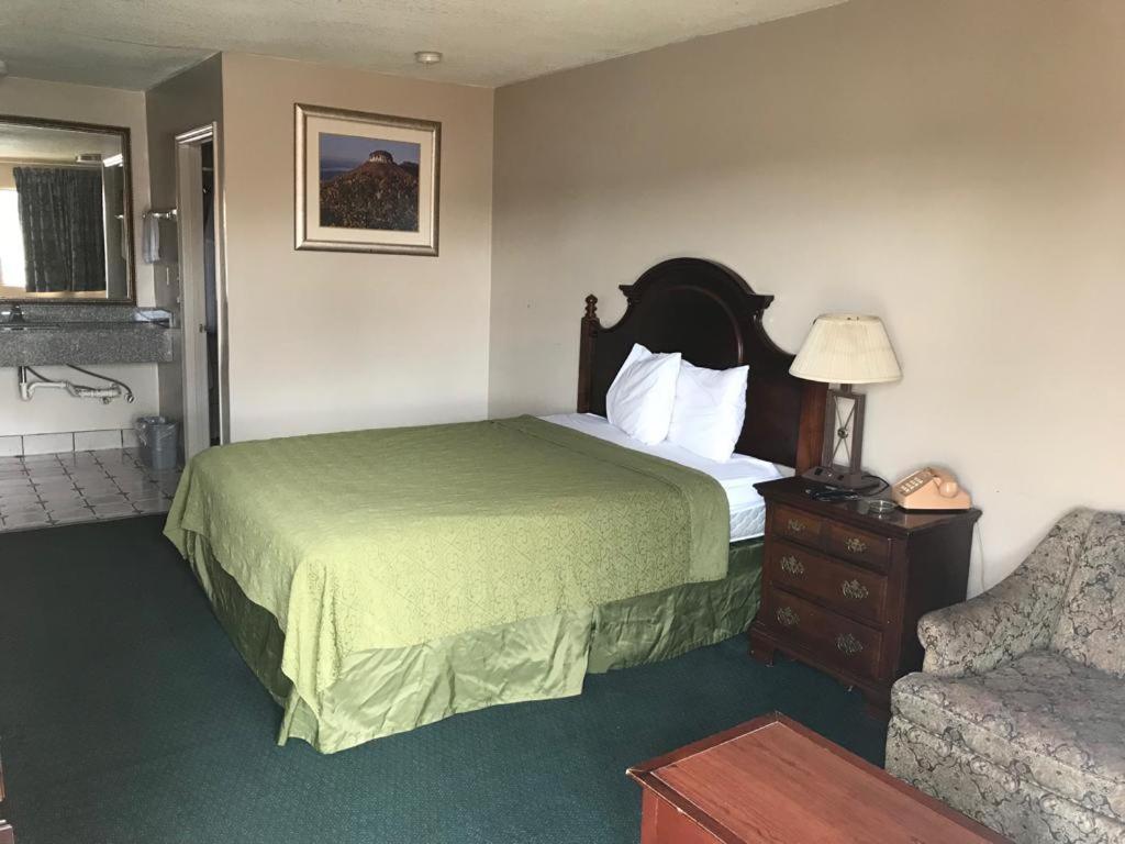um quarto de hotel com uma cama e uma cadeira em Travelers inn em Bethania Station