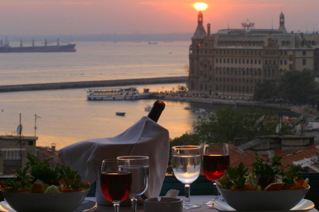 イスタンブールにあるSidonya Hotelのワイングラスとワイン1本付きのテーブル