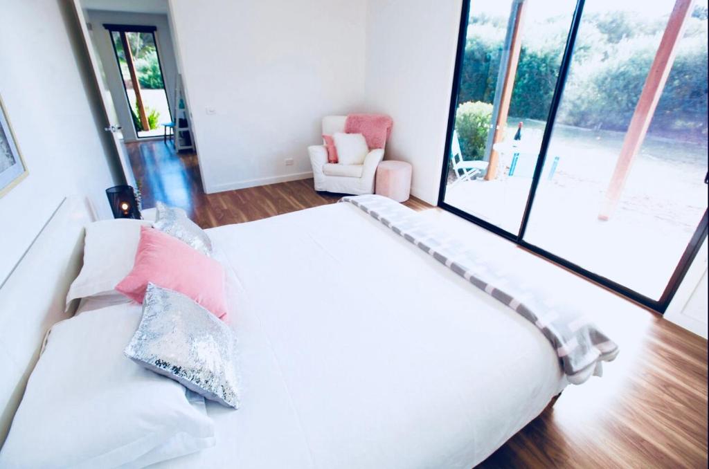 a bedroom with a white bed with pillows at Driftaway on Dundas in Rye