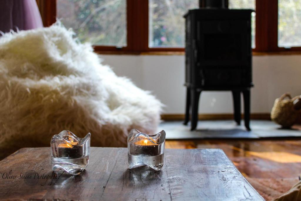 zwei Kerzen auf einem Holztisch in der Unterkunft Tomah Retreat - Studio RELAX with fireplace in Mount Tomah