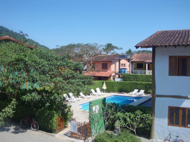 - une piscine dans une cour avec des chaises et une maison dans l'établissement Residencial Kahunas II, à São Sebastião