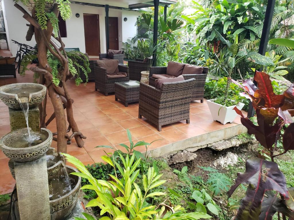 a patio with couches and chairs in a garden at The Balboa Inn in Panama City