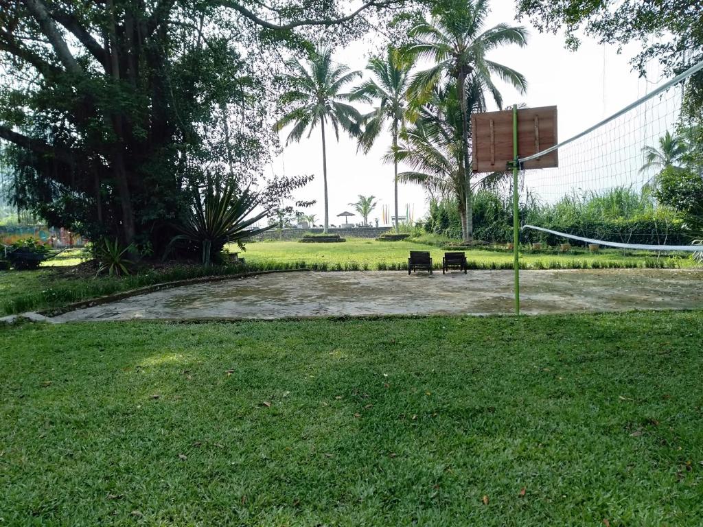 a park with a volley ball hoop in the grass at Bagus Bay Homestay in Tuktuk Siadong