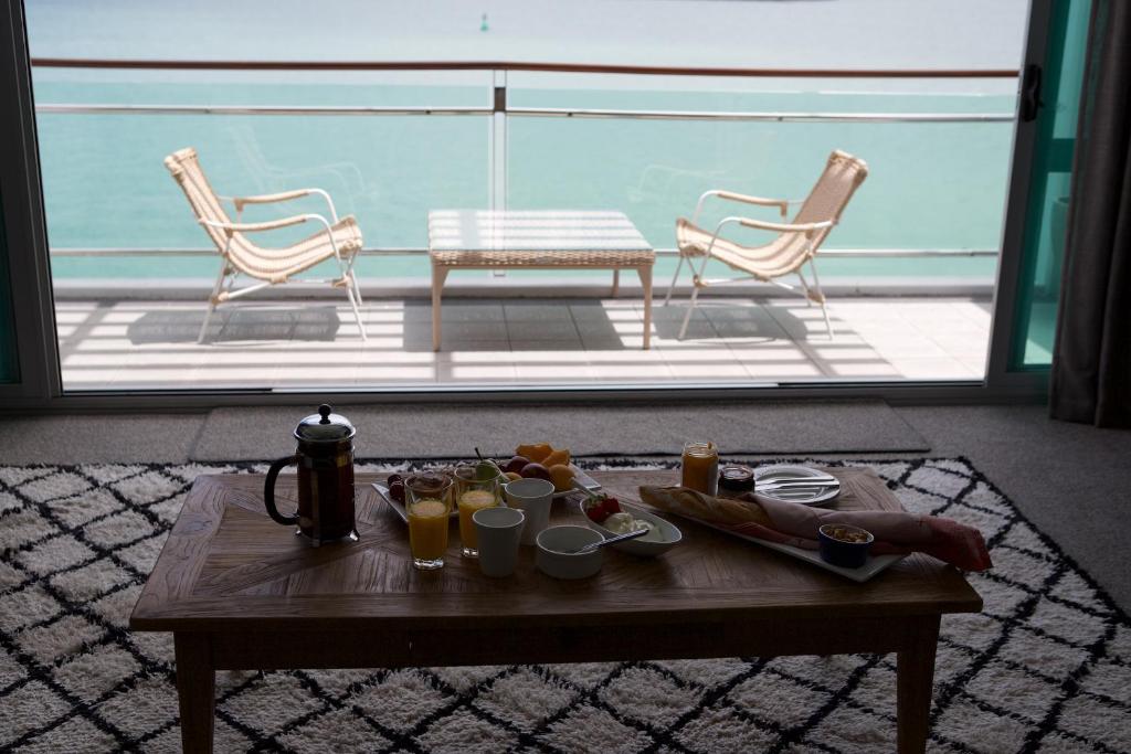 a coffee table with drinks and chairs on a patio at Auckland Waterfront Serviced Apartments on Prince's Wharf in Auckland