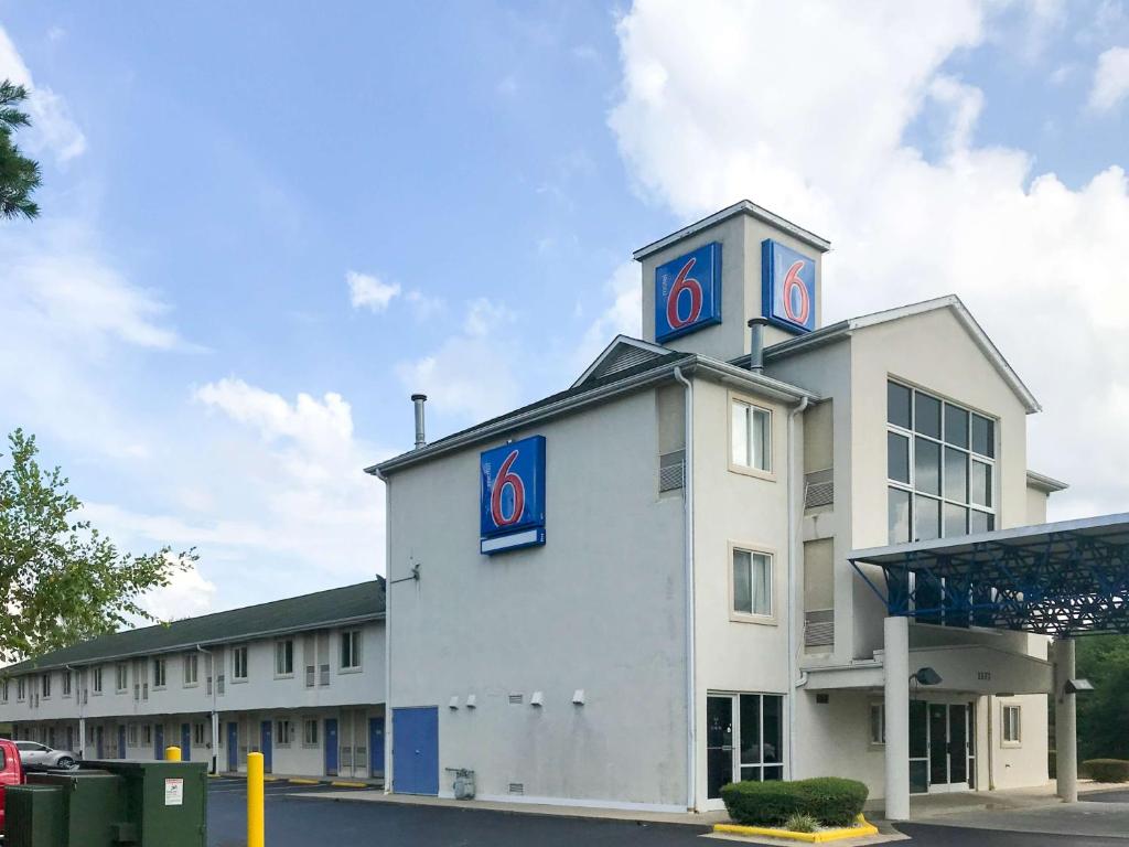 a large white building with blue and red signs on it at Motel 6-Statesville, NC in Statesville