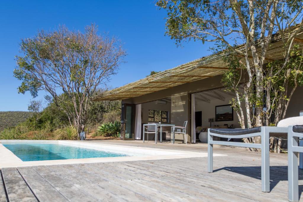a house with a swimming pool and a patio at Hopewell Private Game Reserve in Buyskloof