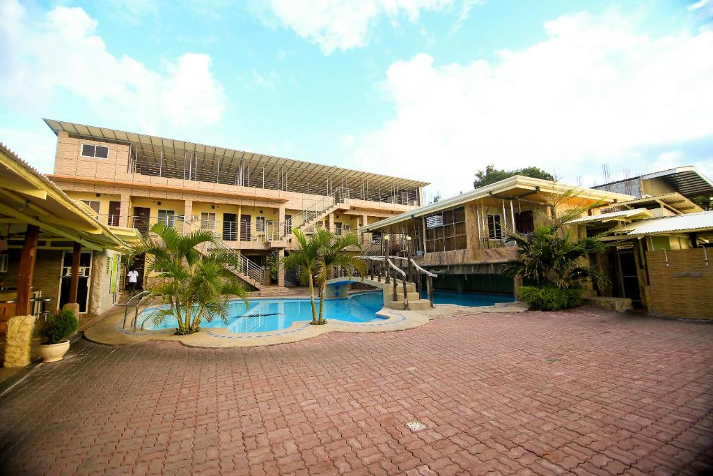 a large building with a courtyard with palm trees at GingGing Hotel And Resort in Oslob