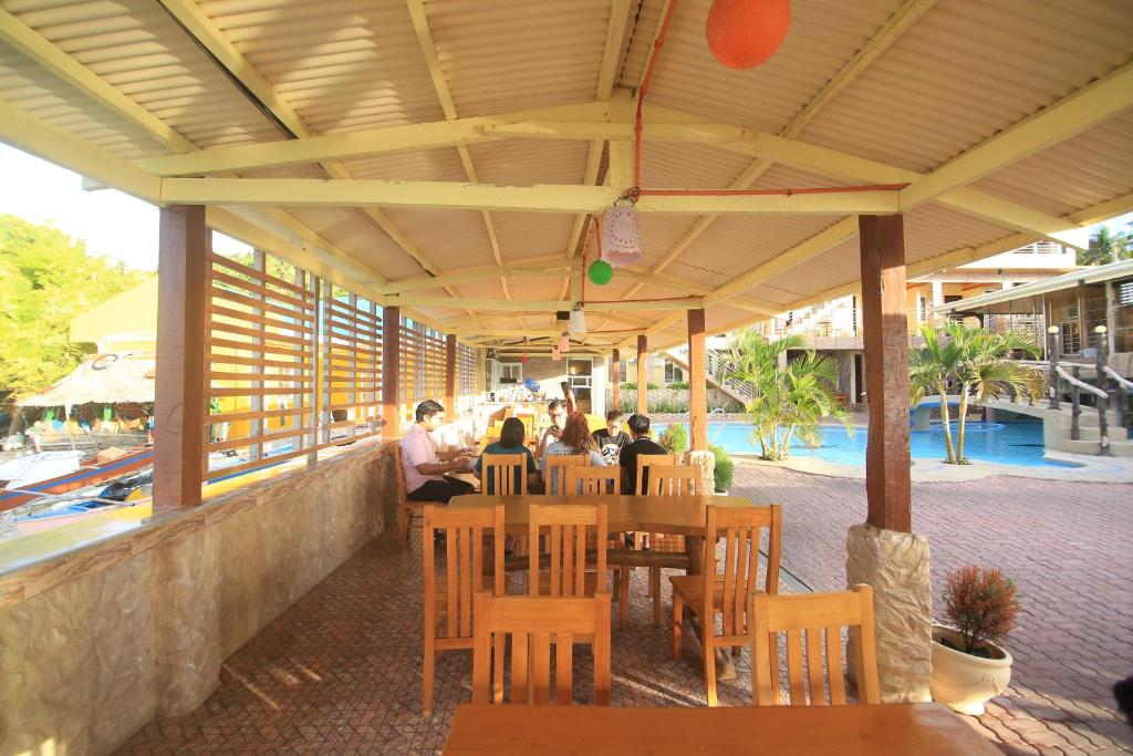 a group of people sitting at a table at a restaurant at GingGing Hotel And Resort in Oslob