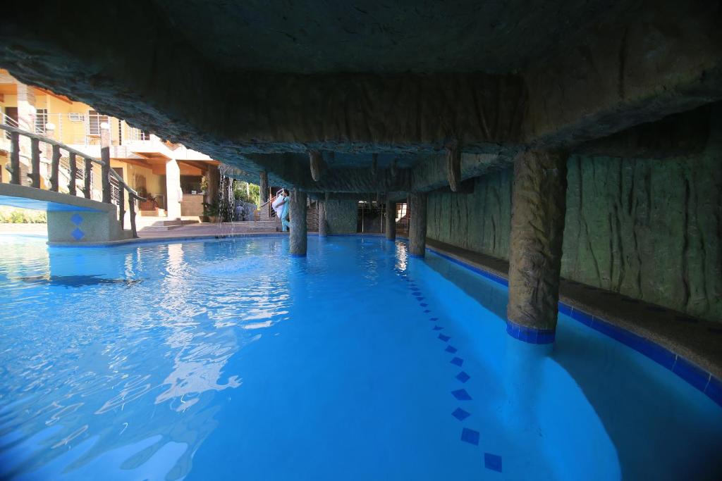 a swimming pool with blue water under a bridge at GingGing Hotel And Resort in Oslob