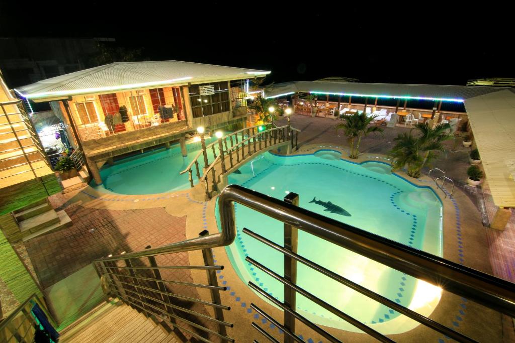 a view of a swimming pool at night at GingGing Hotel And Resort in Oslob